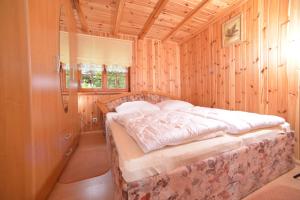 a bedroom with a bed in a wooden room at Domki przy plaży - Pod Wydmami in Dźwirzyno