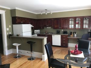 a kitchen with wooden cabinets and a table and chairs at Leaside Executive Apartments in St. John's