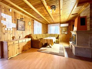 ein Wohnzimmer mit einem Sofa und einem Tisch in der Unterkunft Domki przy plaży - Pod Wydmami in Dźwirzyno