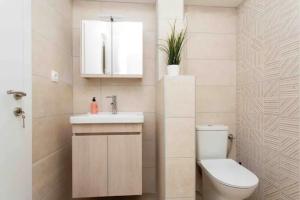 a bathroom with a toilet and a sink and a mirror at Tsimiski #apartment (one bedroom) in Thessaloniki