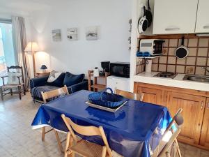 een keuken en een woonkamer met een blauwe tafel en stoelen bij Appartement Soulac-sur-Mer, 3 pièces, 4 personnes - FR-1-648-58 in Soulac-sur-Mer