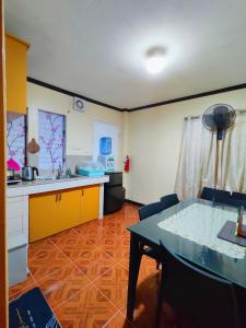 a kitchen and a dining room with a table at Evan's Homestay in Basco