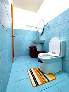 a blue bathroom with a toilet and a sink at Evan's Homestay in Basco