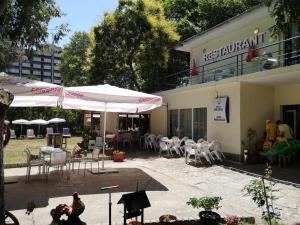 un restaurante con mesas, sillas y sombrillas en хотел Русалка, en Varna