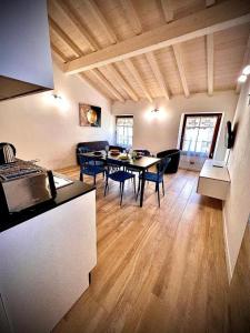 a kitchen and a living room with a table and chairs at Welcome Traveller AMORE APARTMENTS in Bardolino