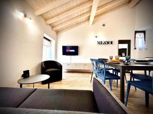 a living room with a table and chairs and a television at Welcome Traveller AMORE APARTMENTS in Bardolino