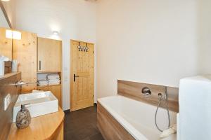 a bathroom with a bath tub and a sink at Landhauswohnung Dosbach in Reit im Winkl