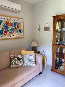 a living room with a couch and a painting on the wall at Solar Água Pipa 119 in Pipa