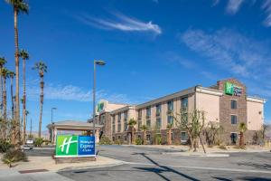 印第奧的住宿－Holiday Inn Express & Suites Indio - Coachella Valley, an IHG Hotel，建筑前有标志的酒店