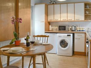 a kitchen with a table and a washing machine at Clip Clops in Findon
