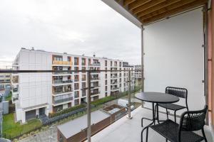 a balcony with a table and chairs and a building at Premium Apartments Poznań Airport by Renters in Poznań