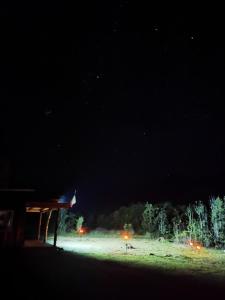 een nachtzicht op een veld met een gebouw bij Cabañas Orillas Del Nilahue in Riñinahue