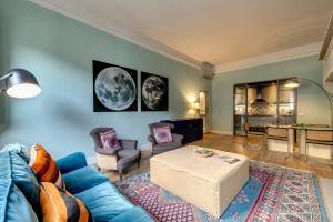 uma sala de estar com um sofá azul e uma mesa em Mamo Florence - Frida Luxury Apartment em Florença