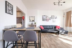 a living room with a couch and a table and chairs at Superbe appartement 1 chambre proximité ULB in Brussels