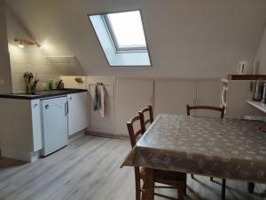 une cuisine avec une table et une fenêtre au plafond dans l'établissement Studio au 2e étage de notre maison de ville, à Caen