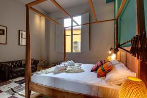 Un dormitorio con una cama con dosel y una ventana. en Frida Luxury Apartment by Mamo Florence, en Florencia