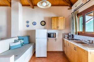 uma cozinha com um frigorífico branco e um lavatório em Althea Accommodation em Agnontas