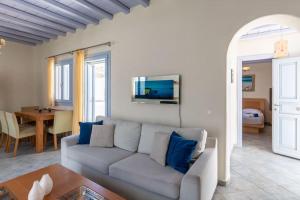 a living room with a couch and a table at 'Nepheli' Mykonean Suite in Ornos