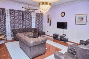 ein Wohnzimmer mit 2 Sofas und einem TV in der Unterkunft Afranasa Inn in Tema