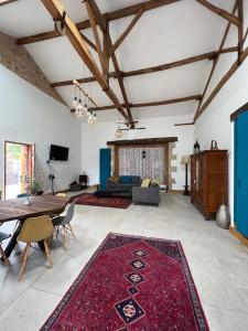 een woonkamer met een tafel en een rood tapijt bij Virolet Barn in Queaux