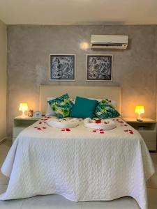 Un dormitorio con una cama blanca con dos platos. en Solar Água Pipa 119, en Pipa