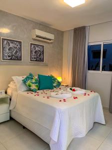 Un dormitorio con una gran cama blanca con flores. en Solar Água Pipa 119, en Pipa