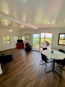 Red Hill Cottage Walcha في Walcha: غرفة معيشة مع طاولة وكراسي