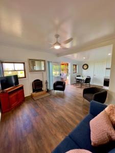 a living room with a couch and a tv at Red Hill Cottage Walcha in Walcha