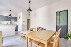 uma cozinha e sala de jantar com uma mesa de madeira e cadeiras em Lovely apartment located 10 min from the sea side em Marselha
