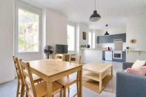 uma cozinha e sala de estar com uma mesa de madeira e cadeiras em Lovely apartment located 10 min from the sea side em Marselha