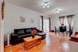 a living room with a black couch and a table at Bonita Casa Arianny By Paramount Holidays in Arona