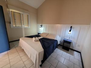 a bedroom with two beds and a window at Pousada Genoveva - Apto com um dormitório in Farol de Santa Marta