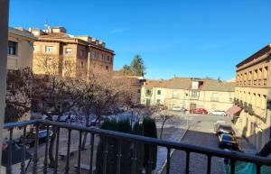 Blick auf eine Stadt mit Gebäuden und einem Parkplatz in der Unterkunft Palacio San Facundo in Segovia