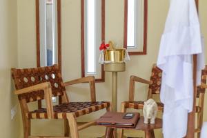 a room with two chairs and a cat sitting on a table at Alma Boutique Hotel in Jambiani