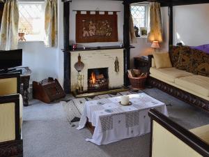 a living room with a table and a fireplace at Apple Tree Cottage in Charmouth