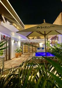 a patio with an umbrella and plants at night at Matisia Hotel Boutique in Guaduas