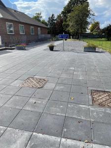 un trottoir avec un panneau bleu de rue devant un bâtiment dans l'établissement Nordkap Bed & Bath, à Holstebro