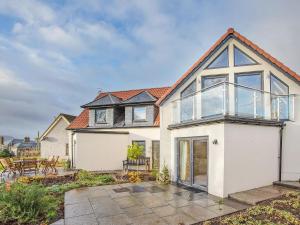 a large white house with glass windows and a patio at Orchard House - Uk40946 in Auchtermuchty