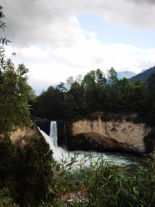 una cascada junto a un río con árboles en Cabañas Orillas Del Nilahue, en Riñinahue
