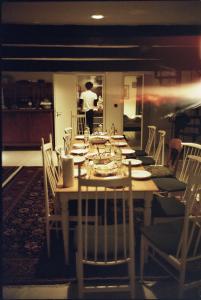 a long table with chairs and a man in the kitchen at Panorama-Loft Fehmarn mit Meerblick in Fehmarn