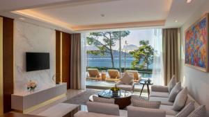 トルバにあるVogue Hotel Supreme Bodrumのリビングルーム(テレビ、ソファ、椅子付)