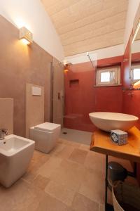 a bathroom with a white sink and a toilet at TRULLI ACQUASALA - Apulian Country Experience in Ostuni +45 photos