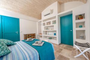 um quarto com portas azuis e uma cama e uma cadeira em TRULLI ACQUASALA - Apulian Country Experience em Ostuni