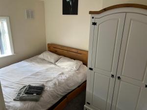 a bedroom with a white bed with a cabinet and a bed sqor at Angie’s hideaway in Balby