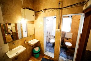 ein Badezimmer mit 2 WCs, einem Waschbecken und einem Spiegel in der Unterkunft MAPLE SOCIAL HUBZ-HOSTEL in Mumbai