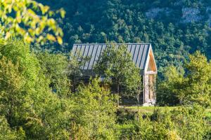 an old barn in the middle of a field with trees at Country House Selo in Pluzine