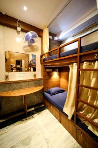 Zimmer mit Etagenbett, Schreibtisch und Etagenbett in der Unterkunft MAPLE SOCIAL HUBZ-HOSTEL in Mumbai