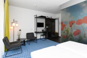 Habitación de hotel con 1 cama y 2 sillas en Hotel De Roode Schuur en Nijkerk