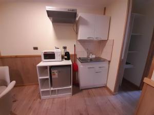 una pequeña cocina con fregadero y microondas en APART HOTEL SUVERAL, en Puerto Montt