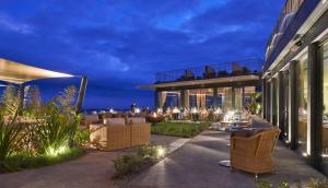 an outdoor patio of a building with chairs and tables at Les Suites at The Cliff Bay - PortoBay in Funchal